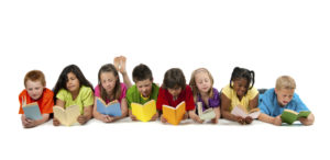 A group of diverse children reading a book.